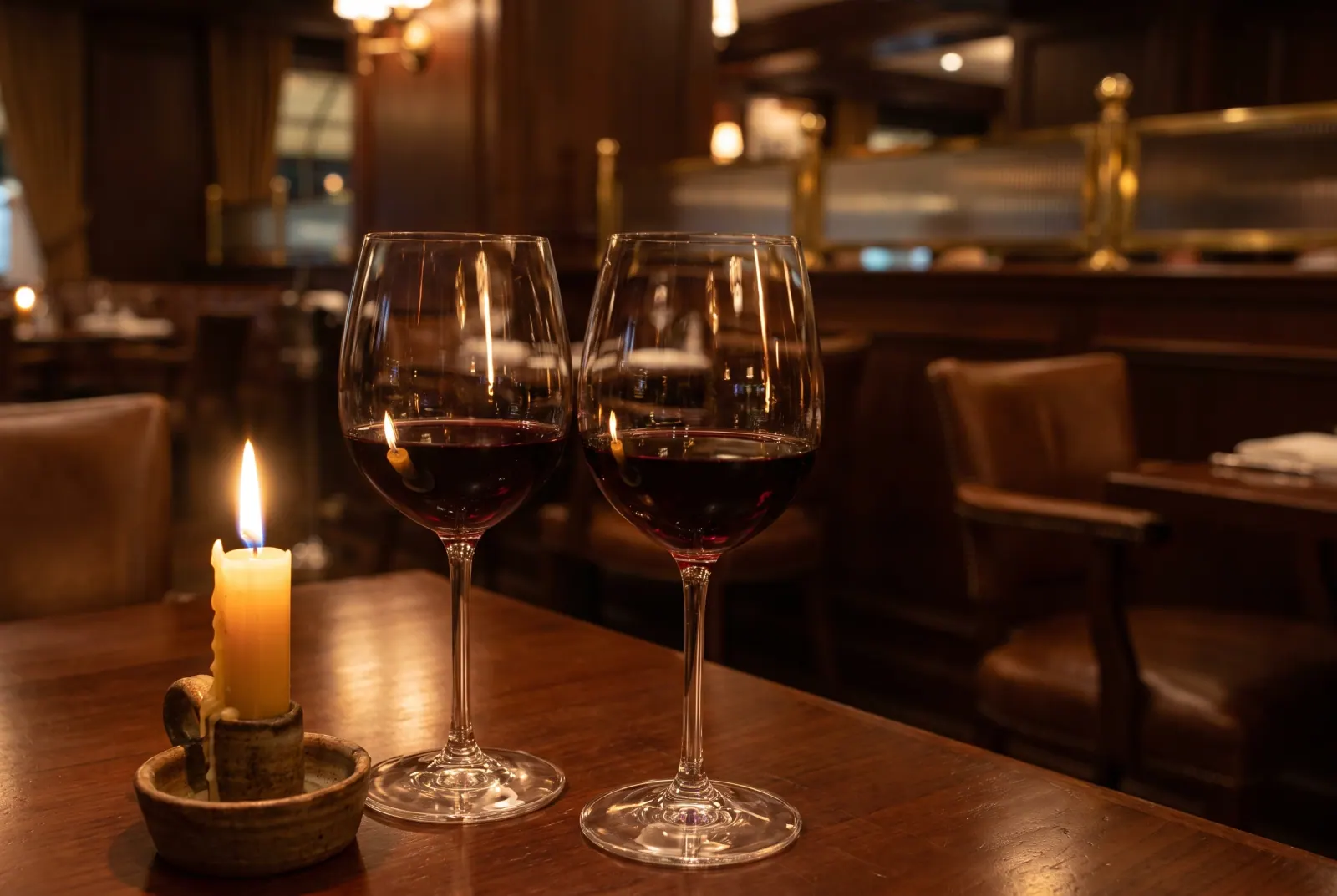 Zwei Gläser Rotwein bei Kerzenlicht